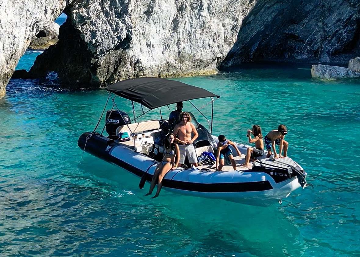 Private boat rental Skiathos 2026, family enjoying Lalaria arch by boat