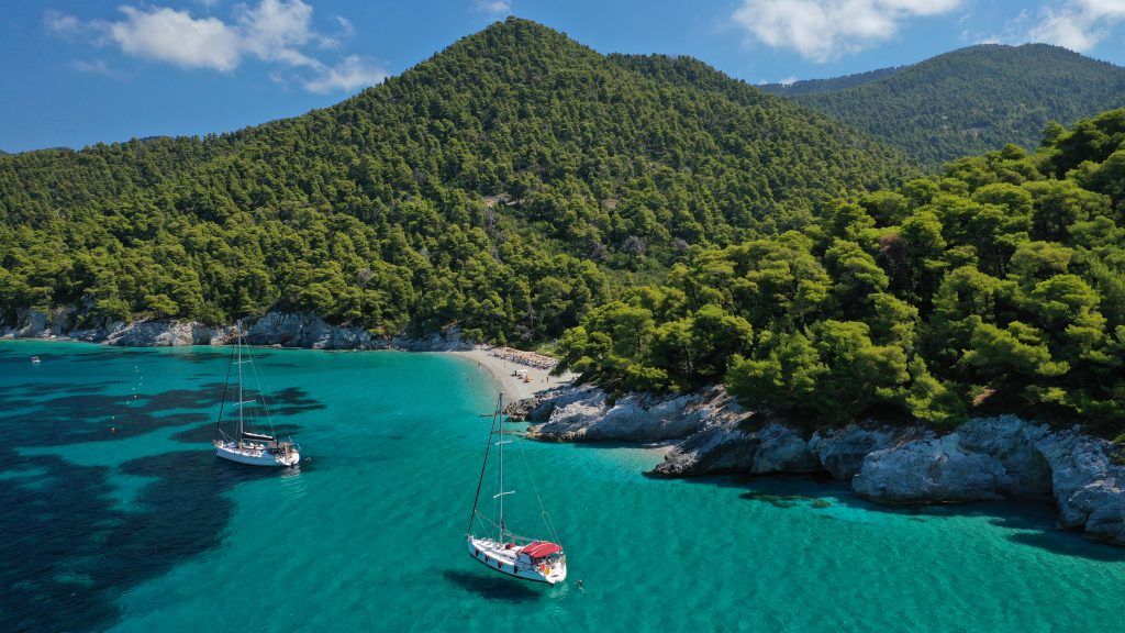 Kastani Beach Skopelos surrounded by pine forests and turquoise water, a famous Mamma Mia filming location.