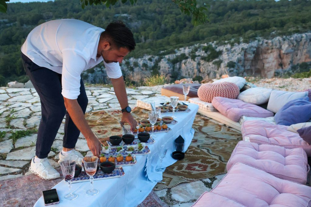 Private chef in Skiathos setting up an exclusive outdoor dinner experience with Skiathos Travellers.